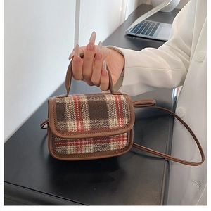 Detailed view of mini plaid tweed crossbody bag with brown faux leather trim and top handle