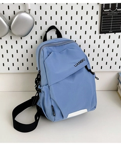Détail du sac de poitrine en nylon bleu clair avec sangles noires et bandes réfléchissantes