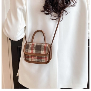 Détail d'un mini sac bandoulière en tweed avec bordure en cuir marron sur blazer blanc