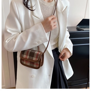 Plaid mini crossbody bag with leather trim worn by a model in a white blazer