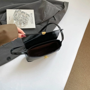 Sac baguette en cuir verni noir brillant avec fermoir doré et doublure marron