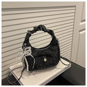 Detail of black pleated crescent bag featuring floral embroidery, pearls, and lace bows