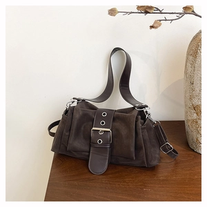 Détail du sac à main en daim marron chocolat avec œillets argentés et boucle rétro