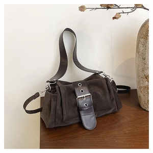 Détail d'un sac à bandoulière vintage marron foncé avec large boucle en cuir poli