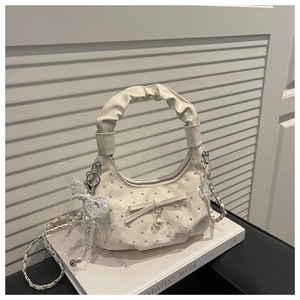 Detail of hobo bag with white lace, rhinestone accents, and elegant pearl bow pendant