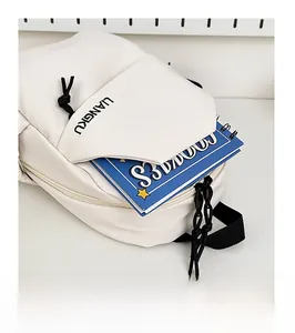 Gros plan de la poche avant d'un sac de poitrine blanc cassé avec un carnet bleu