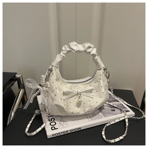 Detailed shot of white pleated handbag with floral beads, pearl charm and bow accent