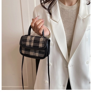 Close-up of black and white checkered pattern on small urban crossbody shoulder bag