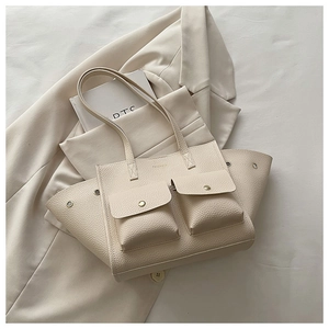 Détail du sac cabas blanc cassé à grain litchi avec deux poches avant et boucles dorées