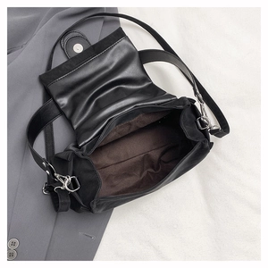 Détail de l'intérieur du sac en cuir noir avec fermoir magnétique et crochets argentés