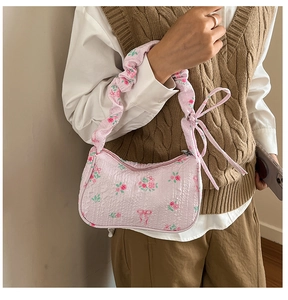 Dettaglio borsa a fiori con trama a rilievo, nastro decorativo e zip in metallo argento
