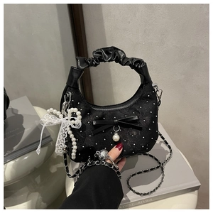 Detail of black pleated crescent bag with pearl bow charms and lace ornaments