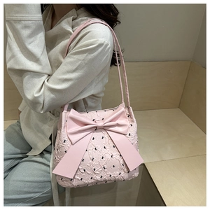 Detailed view of pink bucket bag with large bow and black butterfly embroidery accents