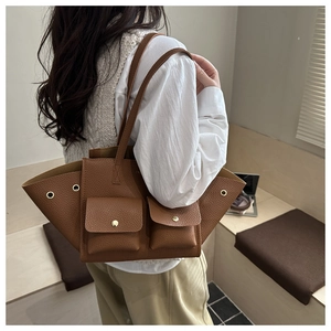 Détail du sac cabas en cuir marron à motif litchi avec poches avant à boucles métalliques