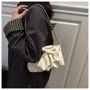 Borsa a spalla bianca a nuvola con fiocco indossata da modella su sfondo neutro