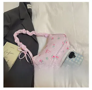 Dettaglio della borsa a spalla rosa floreale con motivo a rose e tessuto strutturato