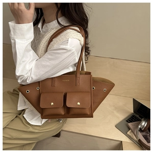 Détail d'un sac cabas marron texture lychee avec poches à boucles et logo doré élégant