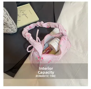 Dettaglio della capacità interna della borsa a pieghe a fiori rosa con cosmetici