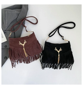 Détail de sacs seaux en daim mat avec pendentif cerf métallique et franges noires et marron