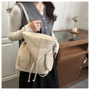Dettaglio ravvicinato dello zaino in peluche beige con orecchie di coniglio morbide