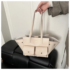 Dettaglio della borsa tote in pelle litchi bianco sporco con doppie tasche e borchie in metallo