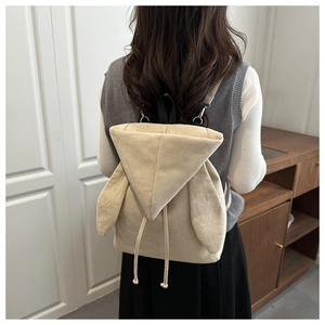 Dettaglio dello zaino di peluche beige con graziose orecchie di coniglio e coulisse