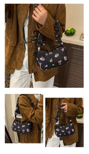 Dettaglio borsa trapuntata nera con motivi floreali rosa e manici arricciati eleganti
