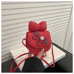 Close-up of red crossbody bag featuring quilted patterns and a cute horse embroidery