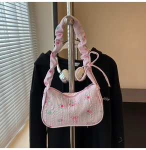 Detailed view of pink floral ruffled shoulder bag with soft souffle pleats and bow ties