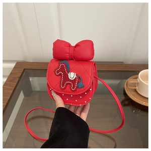 Detail of red girl's crossbody bag with plush horse embroidery and big bow decoration