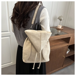 Dettaglio dello zaino in pelle scamosciata beige con orecchie di coniglio e chiusura a lacci