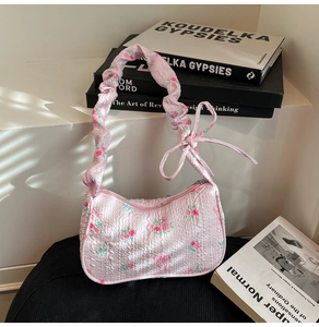 Floral pink underarm bag with bubble texture and ribbon bow detail on white surface