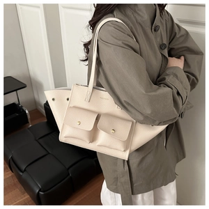 Dettaglio della borsa tote bianco crema con trama litchi, bottoni e stampa moda