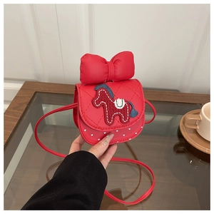 Detail showing red girls quilted crossbody bag with horse embroidery and large bow