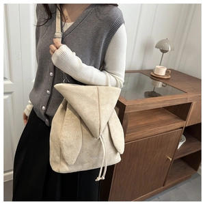 Dettaglio dello zaino in pile beige con design a orecchie di coniglio e chiusura a coulisse
