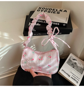 Detailed texture of pink floral ruched shoulder bag with a romantic bow and rose pattern
