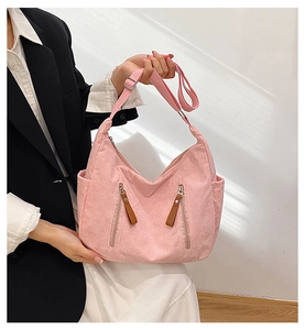 Pink corduroy tote bag detail with dual zipper front pockets and adjustable strap