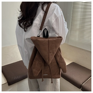 Dettaglio dello zaino in pelle scamosciata marrone scuro con logo Fashion bianco