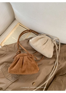 Detail of vintage suede shoulder bags in brown and beige colors on a classic trench coat