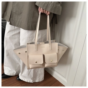 Détail du sac fourre-tout en cuir crème avec extension et poches avant à rabat