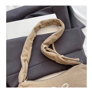 Detail of soft khaki corduroy shoulder bag featuring a wide pleated comfort strap