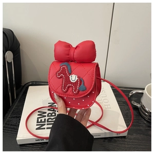 Detail of red girl's crossbody bag with bow, quilted texture, and pony patch embroidery