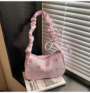 Detail of pink floral pleated underarm bag with bubble gauze texture and bow decor