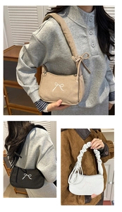 Close-up of corduroy shoulder bag featuring delicate white bow embroidery detail