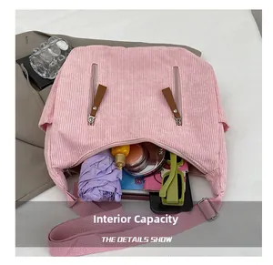 Internal capacity of pink corduroy shoulder bag showing umbrella, makeup, and phone