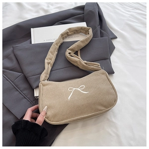 Detail of corduroy shoulder bag with white bow embroidery and wide handle comfort