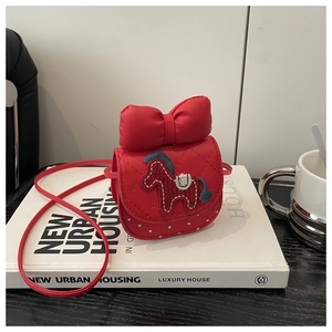 Detail of red quilted child's mini crossbody bag with a large bow and horse embroidery