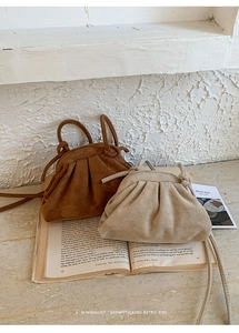 Close-up of pleated suede cloud bags in dark brown and beige with minimalist thin straps