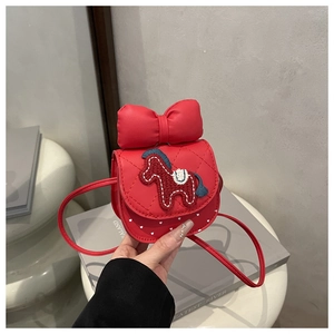Detail view of red girls' crossbody bag with leather bow and knitted pony pattern
