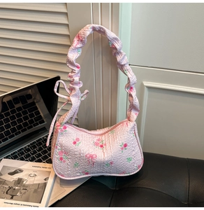 Close-up of pink floral underarm bag featuring bubble fabric and ribbon detail
